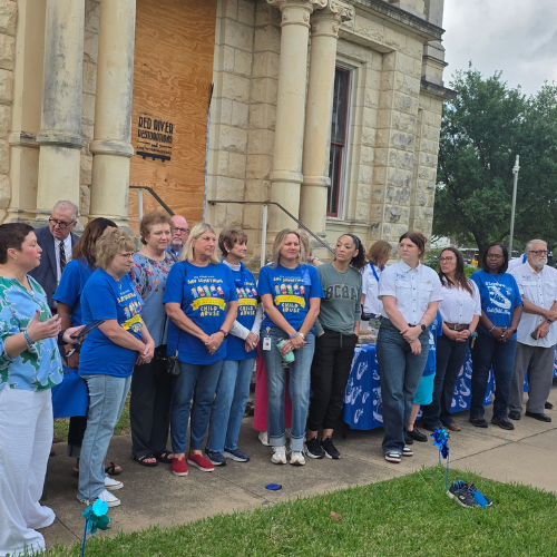 Board members with CASA of Milam County standing with community leaders during a Child Abuse Prevention Month proclamation.