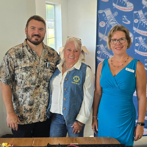 CASA of Milam County supporters standing together near a Taste of Milam event display.