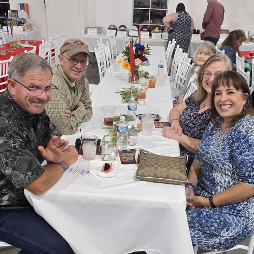 Guests seated at a white table during Taste of Milam, enjoying food and community in support of CASA of Milam County.
