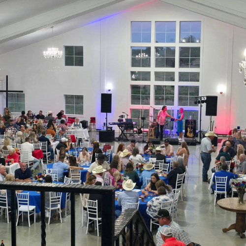 Wide view of guests seated at Taste of Milam with live music on stage during the CASA of Milam County fundraiser.