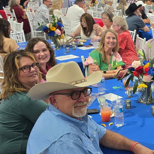 Community supporters gathered around a table at Taste of Milam, a fundraising event for CASA of Milam County.