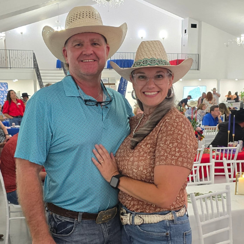 Two guests in western attire smiling at Taste of Milam, a CASA of Milam County fundraising event in Milam County.